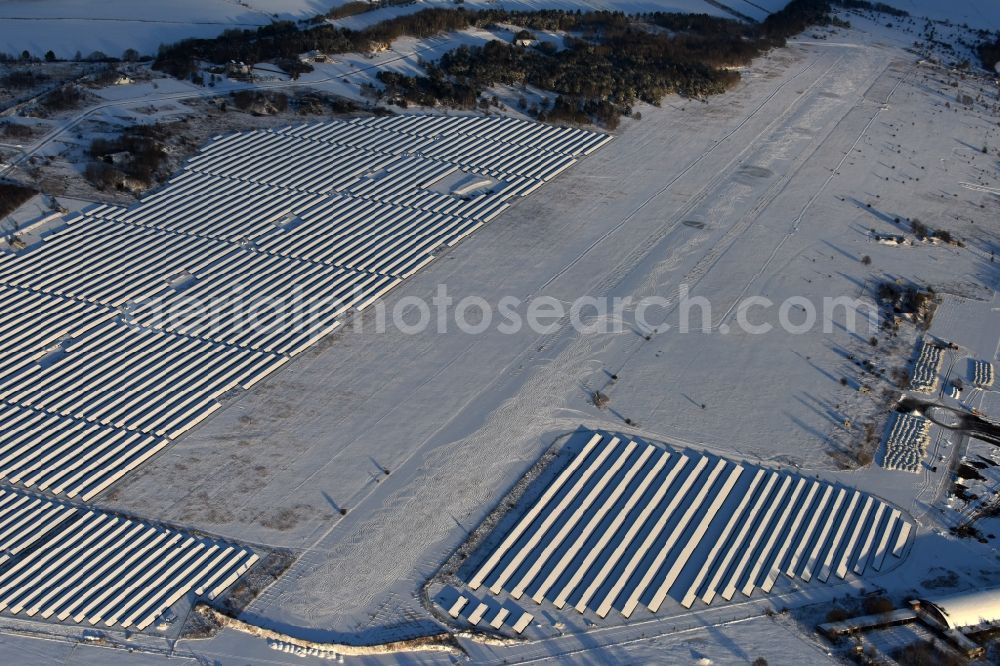 Werneuchen from the bird's eye view: Wintry snowy Solar power plant and photovoltaic systems on the airfield in Werneuchen in the state Brandenburg