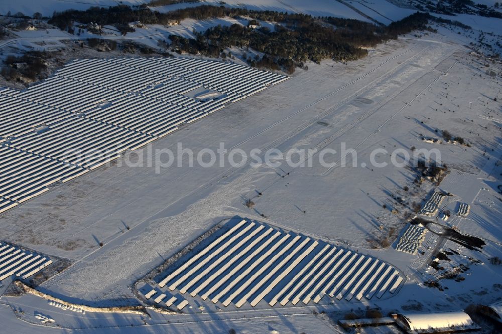 Aerial image Werneuchen - Wintry snowy Solar power plant and photovoltaic systems on the airfield in Werneuchen in the state Brandenburg