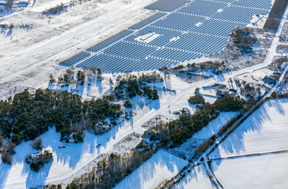 Werneuchen from the bird's eye view: Wintry snowy solar power plant and photovoltaic systems on airfield in Werneuchen in the state Brandenburg, Germany