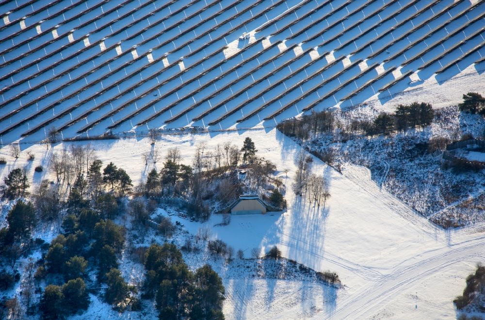 Aerial image Werneuchen - Wintry snowy solar power plant and photovoltaic systems on airfield in Werneuchen in the state Brandenburg, Germany