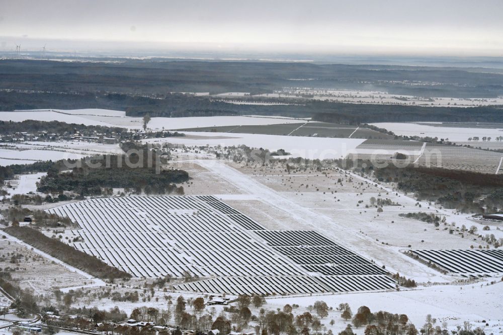 Aerial image Werneuchen - Wintry snowy solar power plant and photovoltaic systems on the airfield on street Alte Hirschfelder Strasse in Werneuchen in the state Brandenburg, Germany