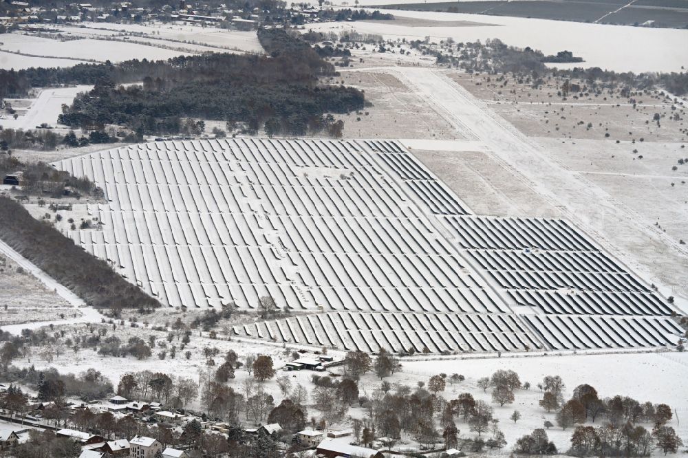 Aerial photograph Werneuchen - Wintry snowy solar power plant and photovoltaic systems on the airfield on street Alte Hirschfelder Strasse in Werneuchen in the state Brandenburg, Germany
