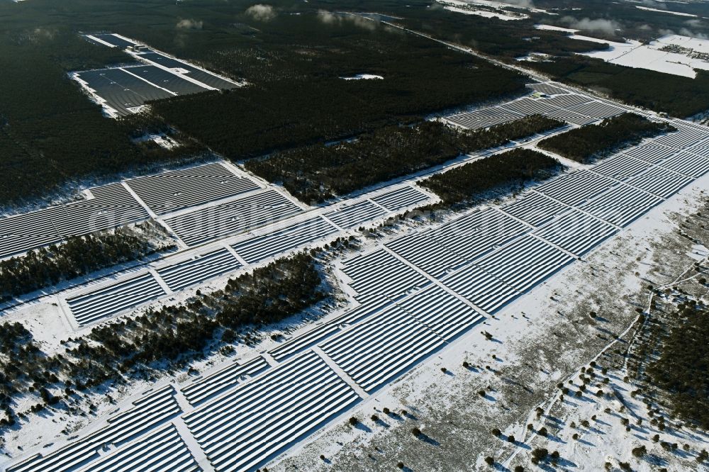 Groß Dölln from the bird's eye view: Wintry snowy solar power plant and photovoltaic systems in Gross Doelln in the state Brandenburg, Germany