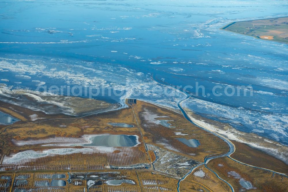 Aerial image Krummhörn - Wintry snowy field edge of a target biotope in the field surface in the Leyhoern nature reserve on the Leybucht in the North Sea in Greetsiel in the state Lower Saxony, Germany