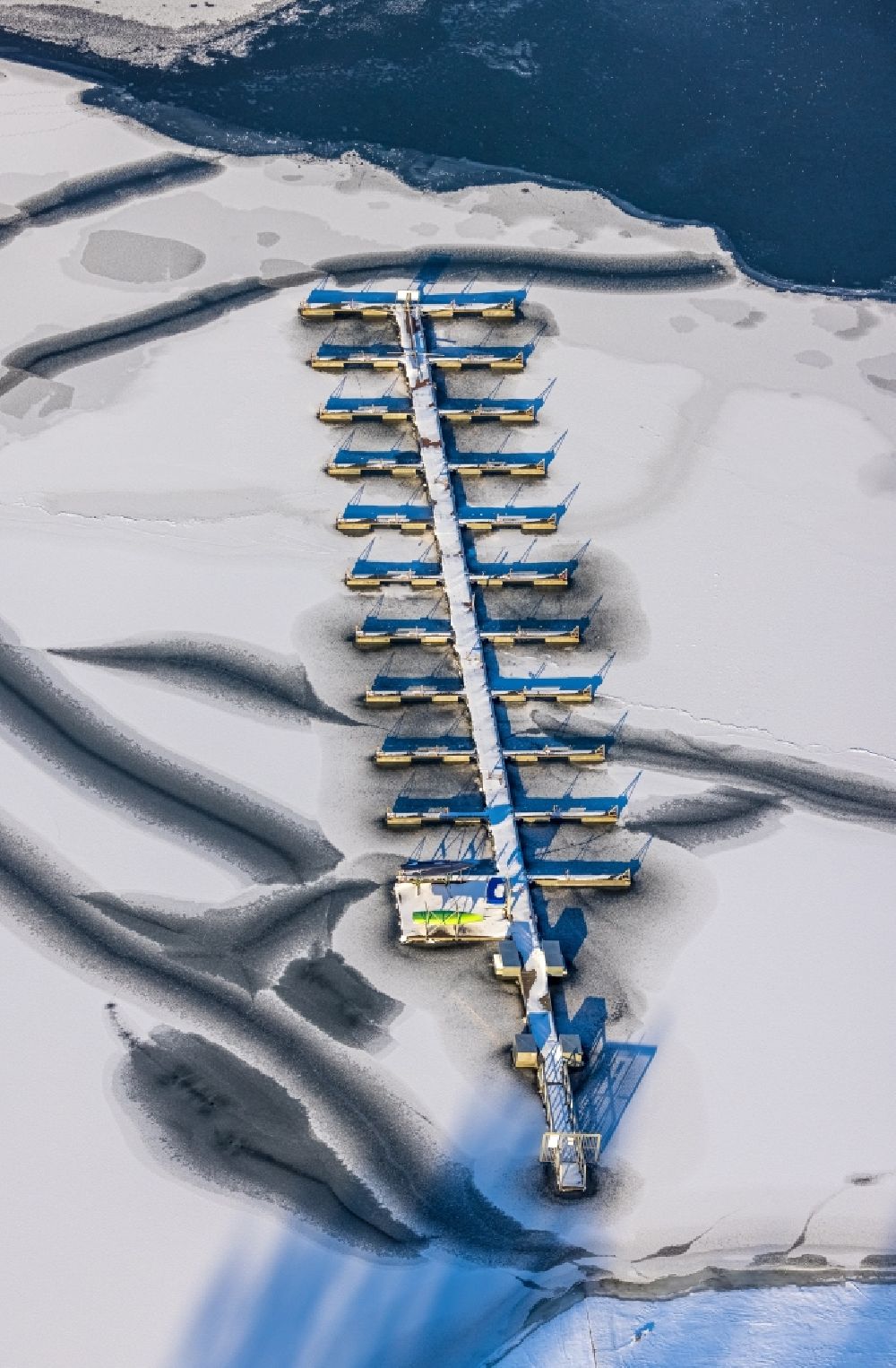 Aerial image Möhnesee - Wintry snowy pleasure boat and sailing boat mooring and boat moorings in the harbor on the sea bank area of Moehnesee in the district Koerbecke in Moehnesee in the state North Rhine-Westphalia, Germany