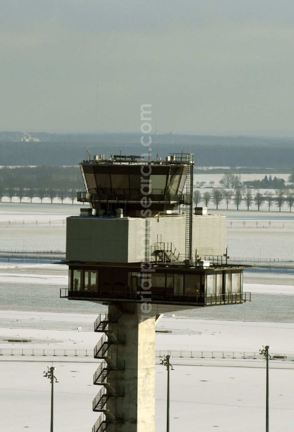 Schönefeld from the bird's eye view: Wintry snowy tower of DFS German Air Traffic Control GmbH on the runways of the BER Airport in Schoenefeld in Brandenburg