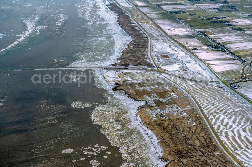 Nessmersiel from the bird's eye view: Wintry snowy ice floe pieces of a drift ice layer on the water surface vor of Nordsee- Kueste in Nessmersiel in the state Lower Saxony, Germany