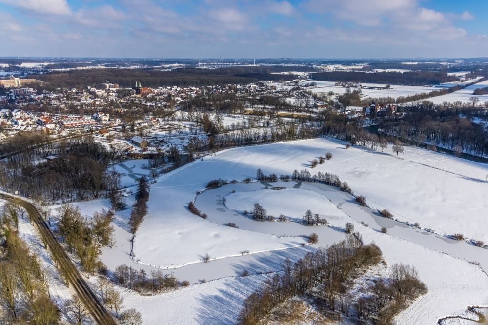 Heessen from the bird's eye view: Wintry snowy curved loop of the riparian zones on the course of the river Muehlengraben in Hamm-Heessen in the state North Rhine-Westphalia, Germany