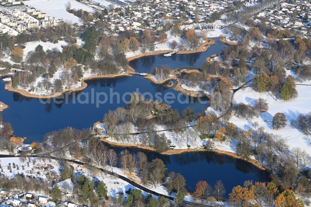 Aerial image Berlin - Wintry snowy riparian areas on the lake area of Hauptsee in the recreation park Britz Garden in Berlin, Germany