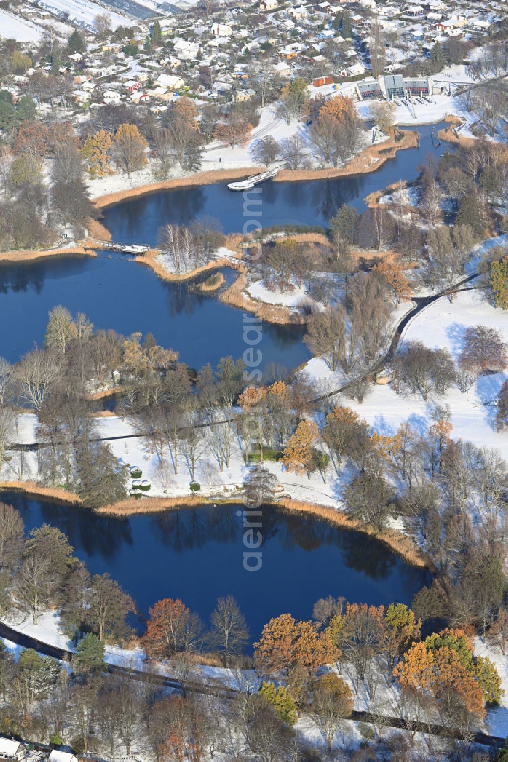 Aerial photograph Berlin - Wintry snowy riparian areas on the lake area of Hauptsee in the recreation park Britz Garden in Berlin, Germany