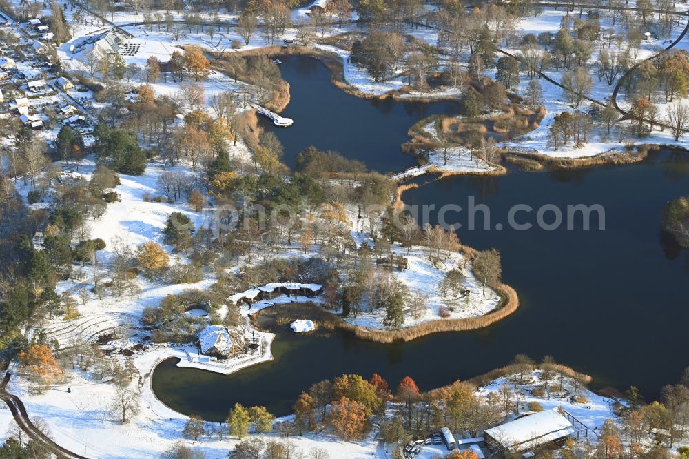 Berlin from above - Wintry snowy riparian areas on the lake area of Hauptsee in the recreation park Britz Garden in Berlin, Germany