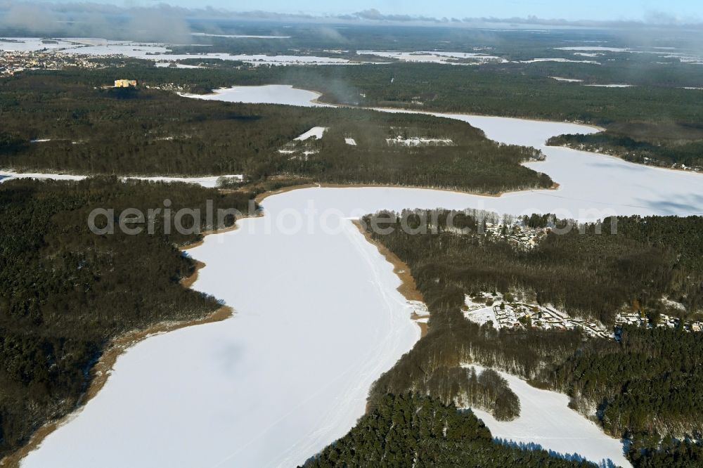 Templin from above - Wintry snowy riparian areas on the lake area of Luebbesee in a forest area in the district Ahrensdorf in Templin in the state Brandenburg, Germany