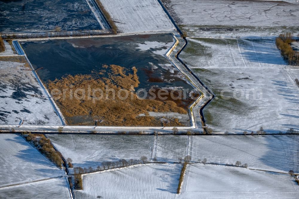 Aerial photograph Westoverledingen - Wintry snowy shore areas of the ponds for fish farming in Westoverledingen in the state Lower Saxony, Germany