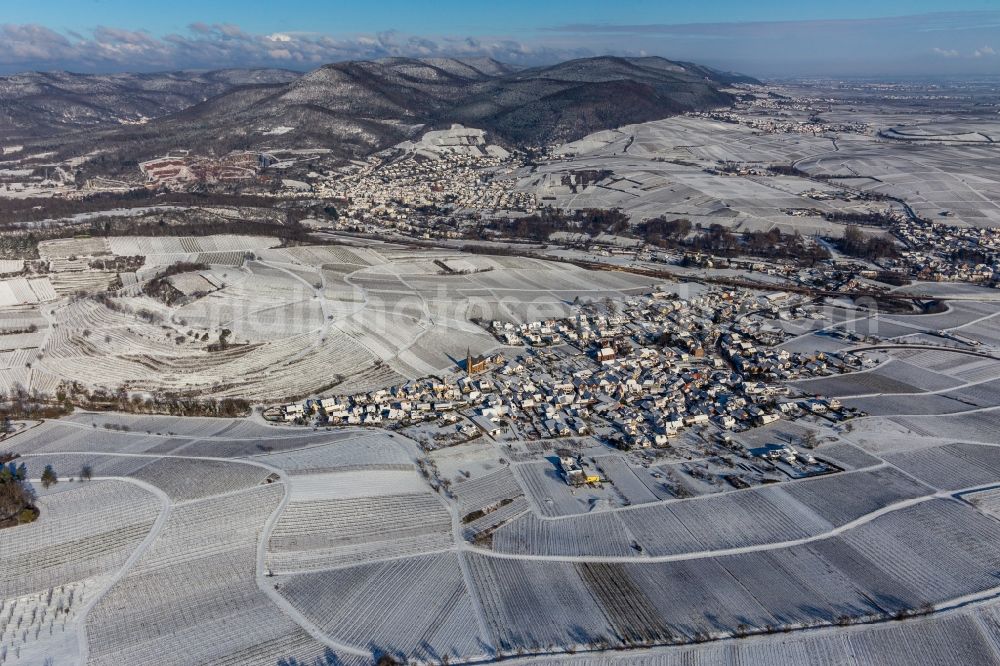 Birkweiler from above - Wintry snowy wine yards surround the settlement area of the village in Birkweiler in the state Rhineland-Palatinate, Germany
