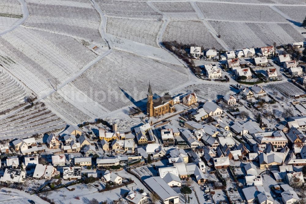 Birkweiler from the bird's eye view: Wintry snowy wine yards surround the settlement area of the village in Birkweiler in the state Rhineland-Palatinate, Germany