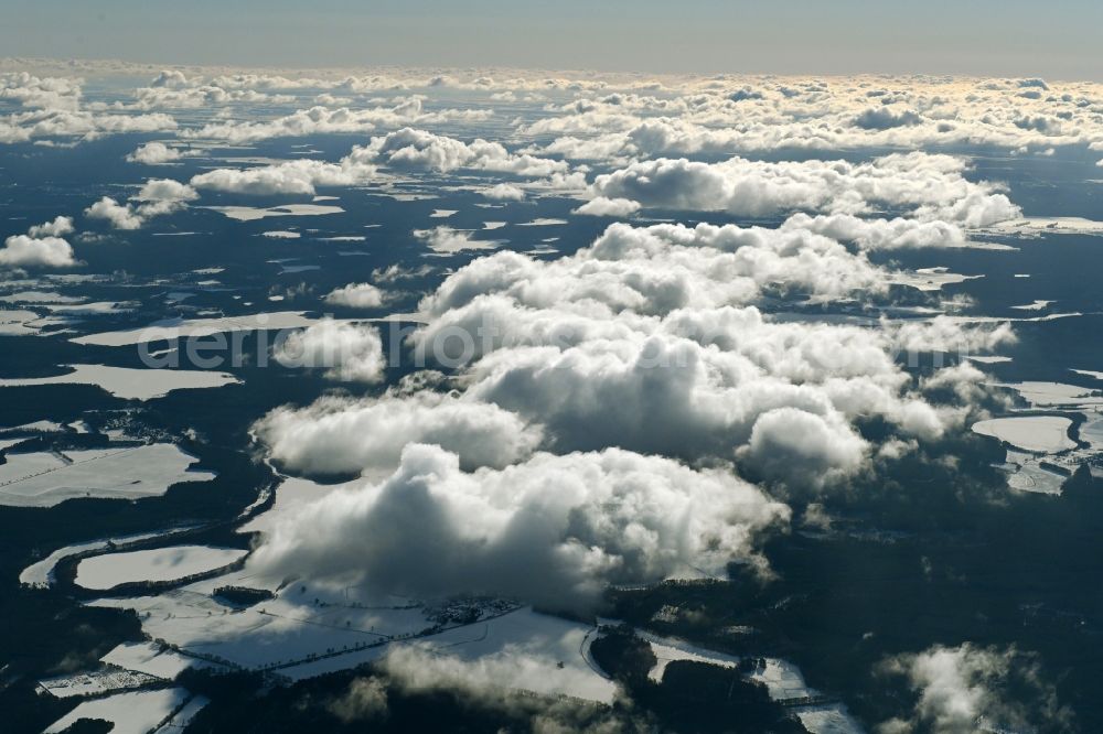Userin from above - Wintry snowy weather conditions with cloud formation over forest areas in Userin in the state Mecklenburg - Western Pomerania, Germany