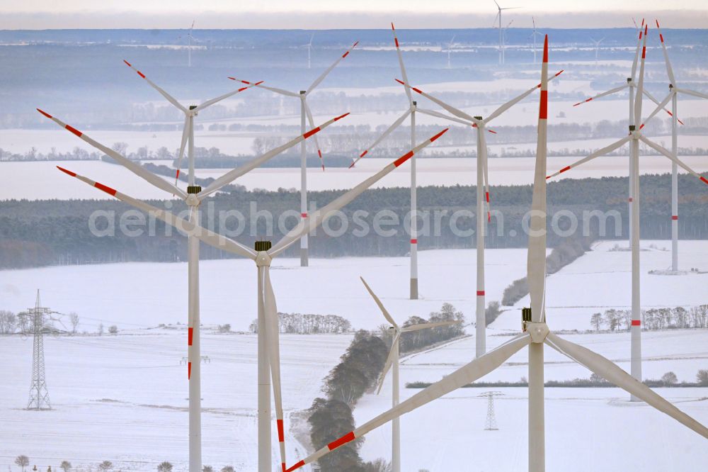 Ladeburg from the bird's eye view: Wintry snowy wind turbine windmills on a field in Ladeburg in the state Brandenburg, Germany