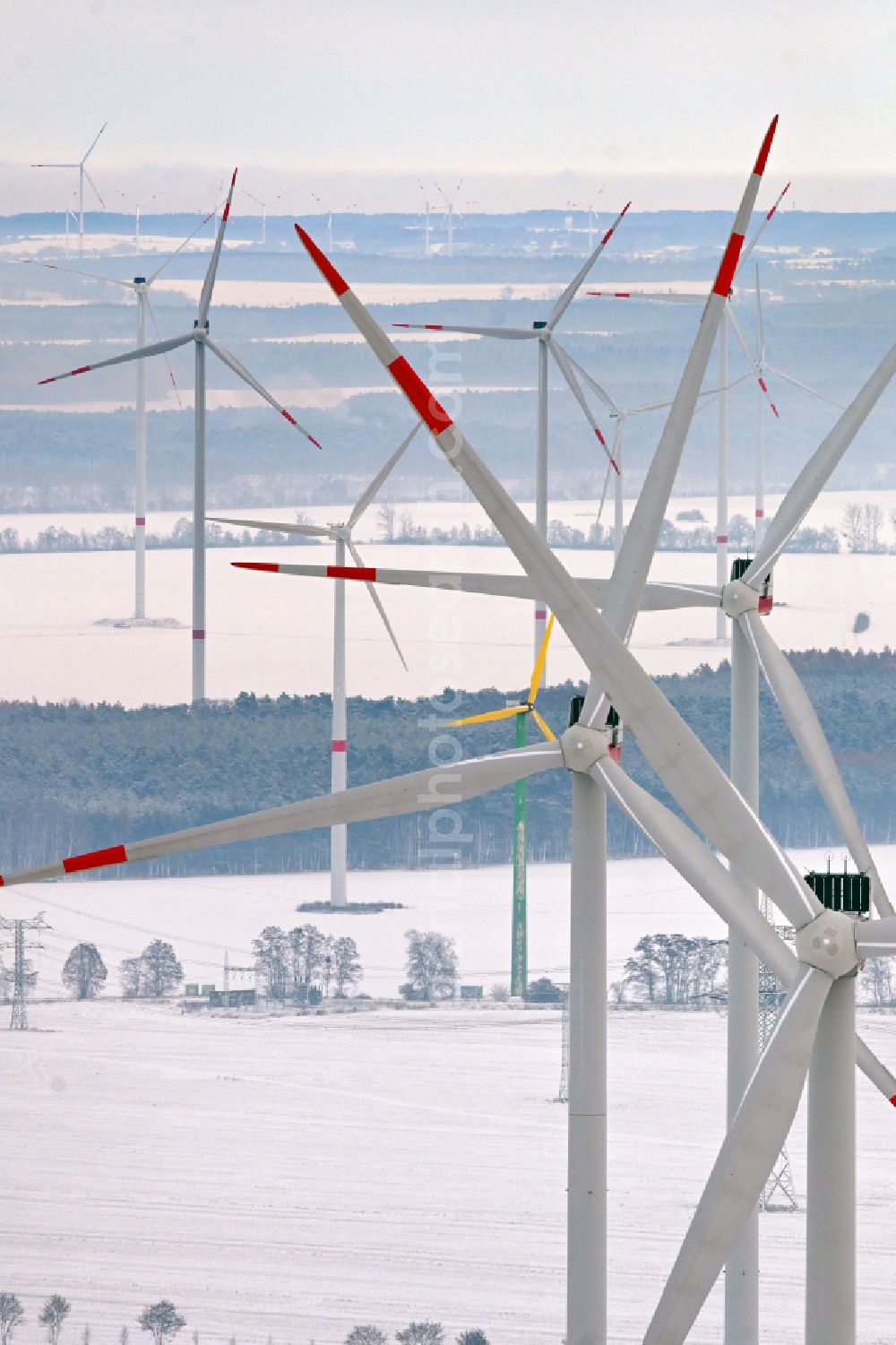 Ladeburg from above - Wintry snowy wind turbine windmills on a field in Ladeburg in the state Brandenburg, Germany