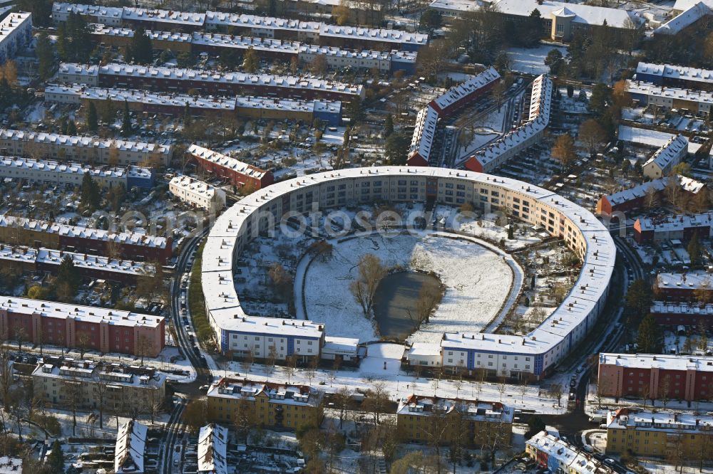 Aerial image Berlin - Wintry snowy Residential area of the multi-family house settlement Hufeisensiedlung on Lowise-Reuter-Ring - Fritz-Reuter-Allee in Britz in the district Neukoelln in Berlin, Germany