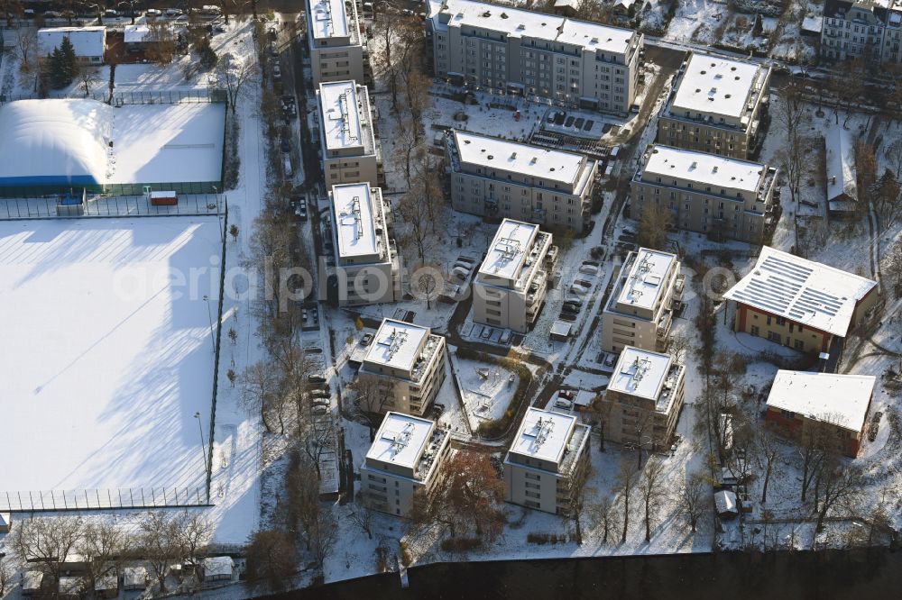 Aerial photograph Berlin - Wintry snowy residential area of a multi-family house settlement on the bank and river of Spree River on street Bruno-Buergel-Weg in the district Schoeneweide in Berlin, Germany