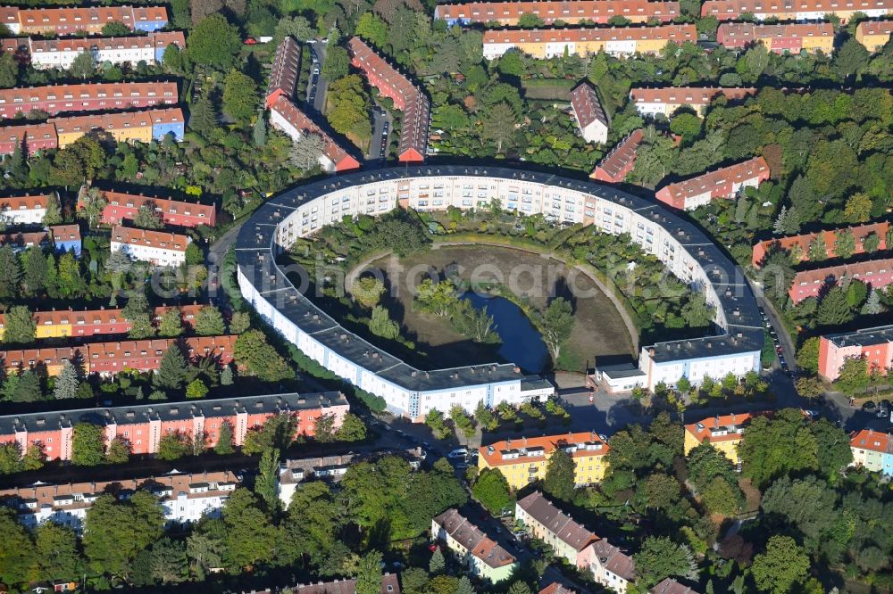 Aerial image Berlin - View of the Horseshoe estate in the Britz part of the district of Neukoelln in Berlin. The Hufeisensiedlung was designed by Bruno Taut and Martin Wagner. It is one of the first projects of social housing and part of the larger settlement Britz - Fritz Reuter city. It is an UNESCO World Heritage Site. The horseshoe itself is still owned by the GEHAG, under the roof of the Deutsche Wohnen AG