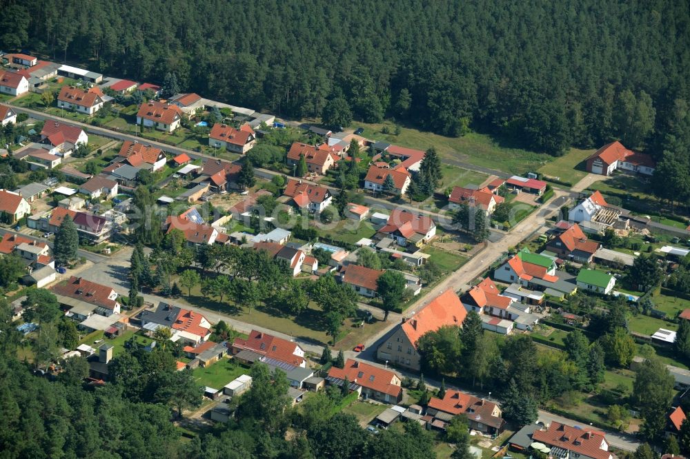 Kummersdorf-Gut from above - Residential area Am Koenigsgraben in a forest in the East of Kummersdorf-Gut in the state of Brandenburg. The residential area with single family and semi-detached houses and gardens is located in a forest along county road L70