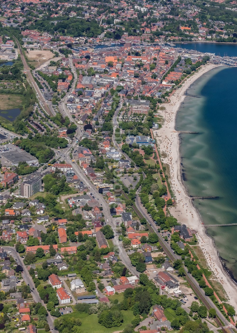 Aerial photograph Eckernförde - Residential area of the multi-family house settlement on both sides of the federal highway B76 with railway line and Baltic Sea beach in Eckernfoerde in the state Schleswig-Holstein, Germany