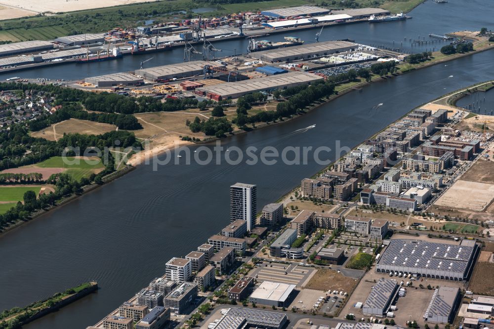 Aerial photograph Bremen - Residential and commercial settlements on Flusslauf of Weser with Holzhafen in the district Ueberseestadt in Bremen, Germany