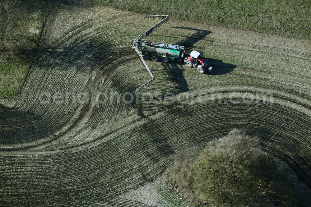 Vertical aerial photograph Kaltenwestheim - Vertical aerial view from the satellite perspective of the spraying manure as fertilizer with tractor and tank trailer on agricultural fields in Kaltenwestheim in the state Thuringia, Germany