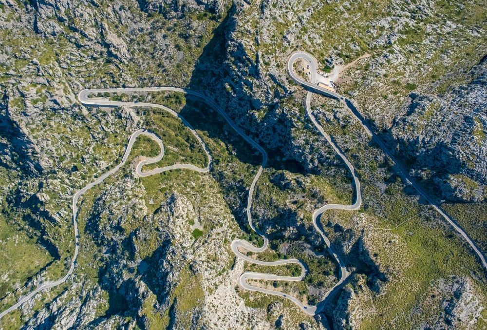 Vertical aerial photograph Escorca - Vertical aerial view from the satellite perspective of the serpentine-shaped curve of a road guide in Escorca at Serra de Tramuntana in Balearic island of Mallorca, Spain