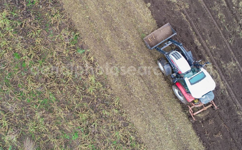 Vertical aerial photograph Groß Klessow - Vertical aerial view from the satellite perspective of the plowing and shifting the earth by a tractor with plow on agricultural fields in Gross Klessow in the state Brandenburg, Germany