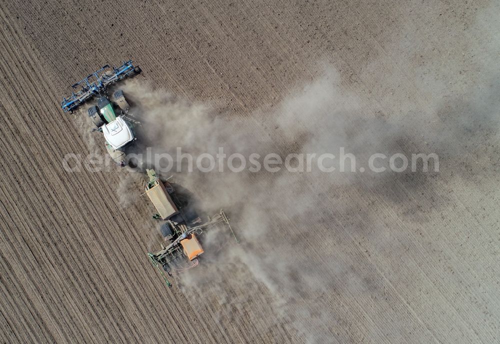 Vertical aerial photograph Jacobsdorf - Vertical aerial view from the satellite perspective of the plowing and shifting the earth by a tractor with plow on agricultural fields in Jacobsdorf in the state Brandenburg, Germany