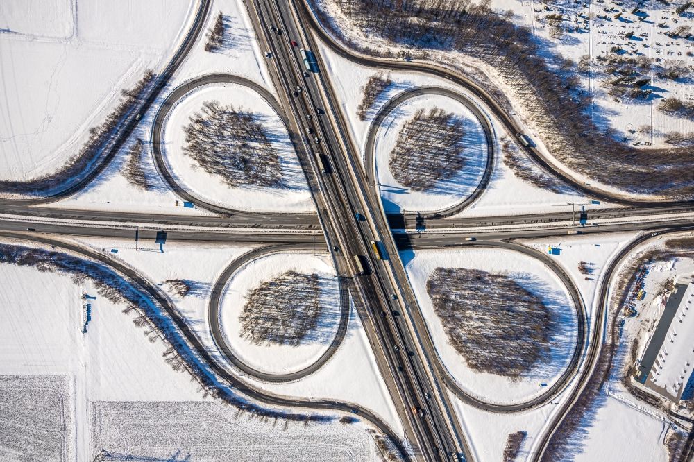 Vertical aerial photograph Unna - Wintry snowy traffic flow at the intersection- motorway A4 , A1 Kreuz Dortmund/Unna in form of cloverleaf in Unna in the state North Rhine-Westphalia, Germany